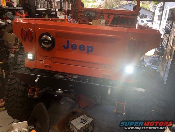Orange Jeep body with "Jeep" in blue letters, aftermarket bumper, and large tires