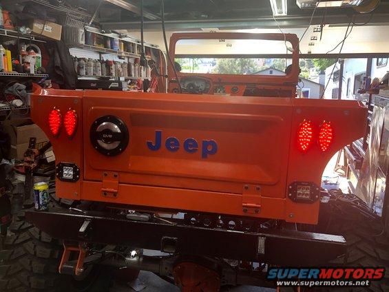 Orange Jeep CJ-7 rear with custom tailgate, LED taillights, and aftermarket bumper
