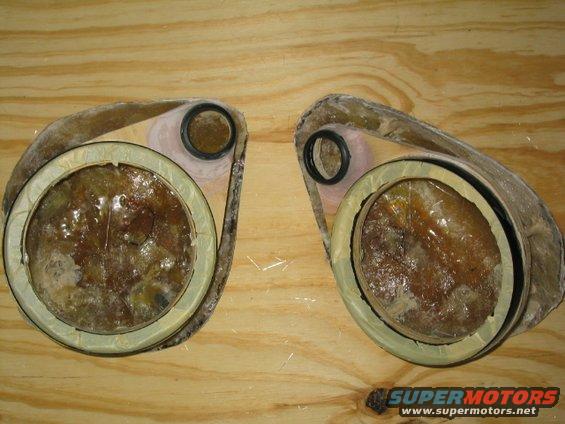 Two fiberglass headlight housings with internal components and rubber seals