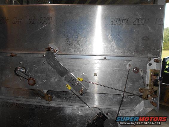 Mechanical assembly with cables and levers on a metal surface.