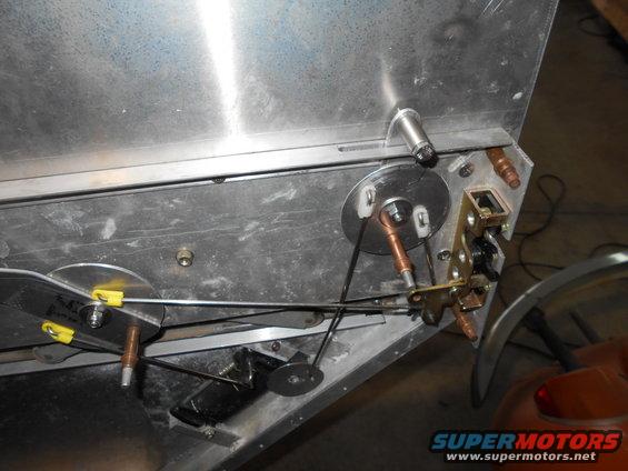 Internal mechanism of a vehicle with cables, pulleys, and latch.