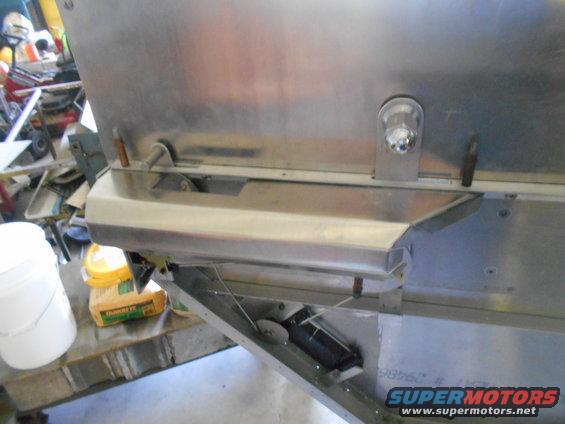 Close-up of a shiny metal vehicle part with a light fixture and wiring.