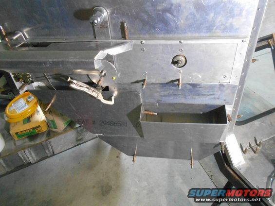 Close-up of custom metal fabrication with fasteners and a toolbox.