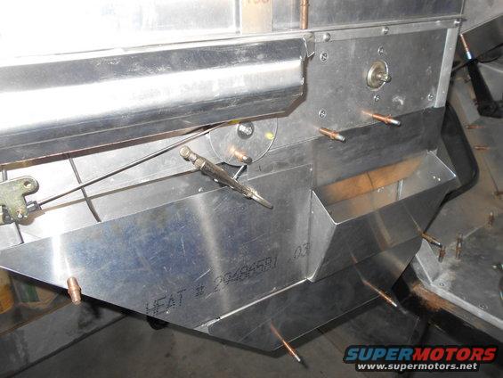 Close-up of vehicle interior aluminum construction with cable mechanism and text.