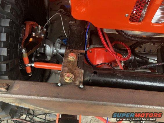 Off-road vehicle suspension and engine parts, including orange shock absorber and red engine component