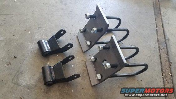 Leaf spring shackles and U-bolts with mounting hardware on concrete