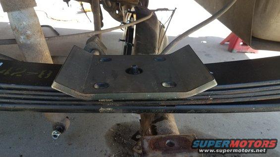 Close-up of a metal plate bolted onto a vehicle's leaf spring