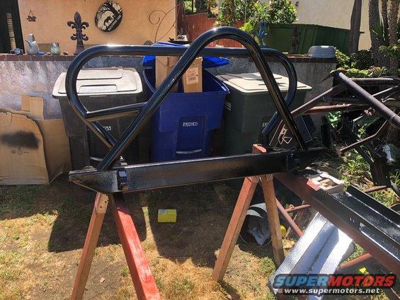 black roll cage and bumper assembly on sawhorses