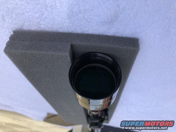 Telescope eyepiece with black cap on gray foam padding