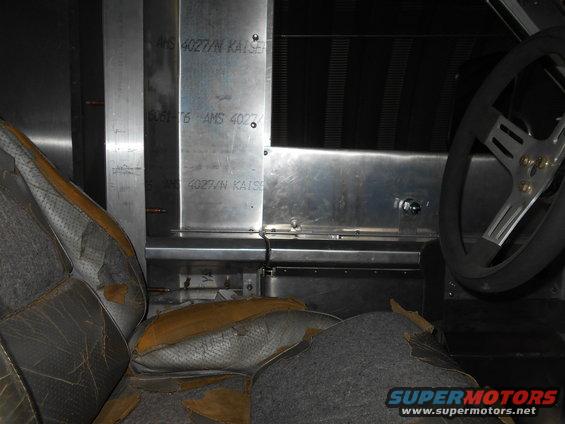 Interior view of worn seats and metal paneling with text 'AMS 4027/N KAISER'