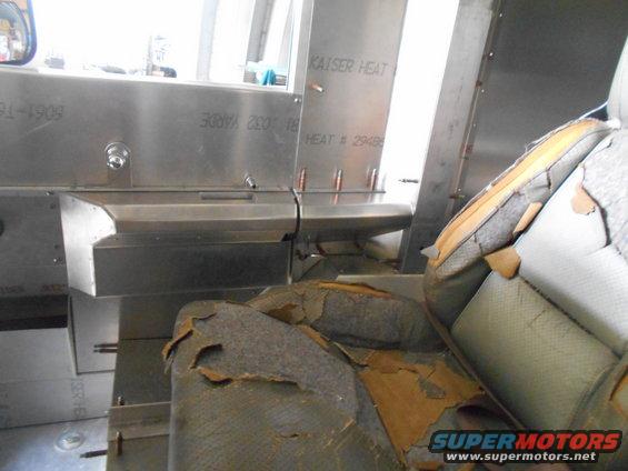 Interior shot showing torn seats and metal paneling with text 'KAISER HEAT'