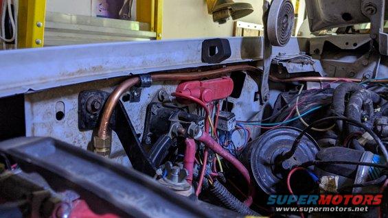Engine compartment with red and black hoses and wiring