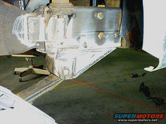 Close-up of heavily modified vehicle suspension with visible welds and bolts