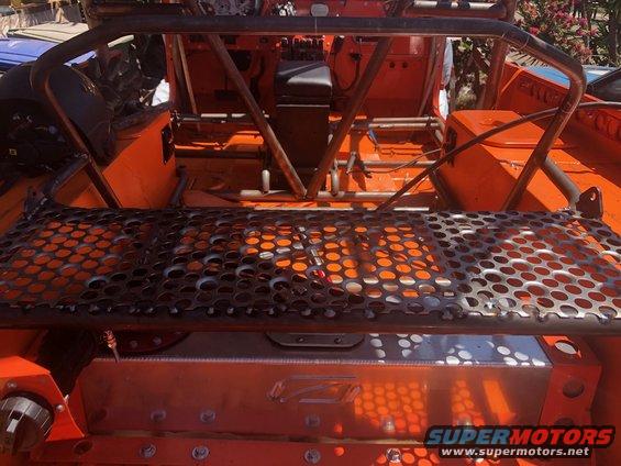 Orange off-road vehicle interior with custom roll cage and perforated metal deck