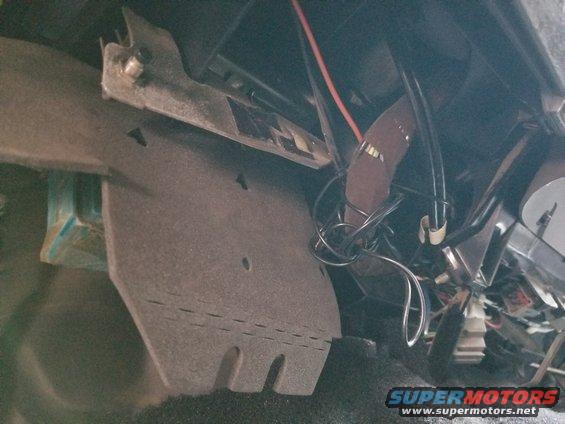 03dashuc.jpg The pushbutton switch through the steel bracket & wad of wire are remnants of the RKE 600Plus system. Its removal is probably why the Right unlock switch doesn't work.

Remove abandoned wiring & repair damage: $60/hr clock time