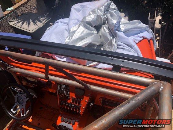 Orange off-road vehicle interior with custom roll cage and aftermarket steering wheel