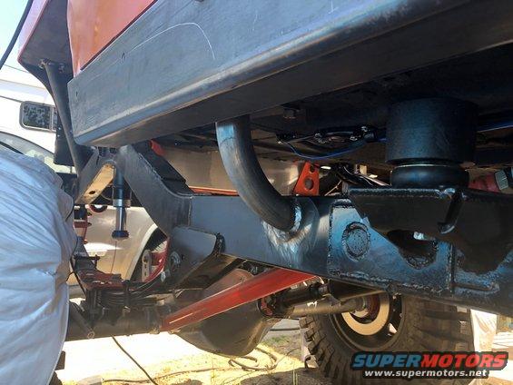 Undercarriage view of a Jeep Wrangler showing custom suspension components and frame modifications