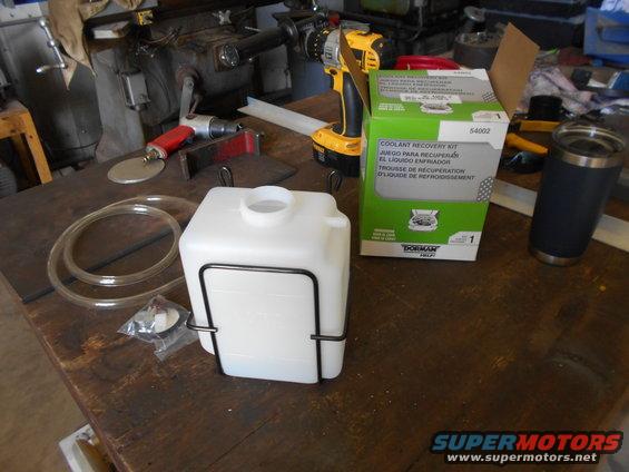 Coolant recovery kit, tubing, and a drill sit on a workbench next to a grinder