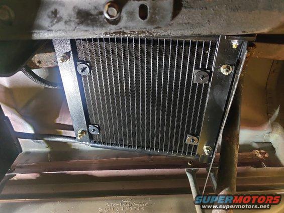 20200730 - Transmission controller installed under the passenger seat against the frame. The angle is different and I'm hoping there will be enough air flow that the fan won't have to engage too much. There is a piece of metal below it to encourage air through it, and one forward of it to help block debris from the front right tire.