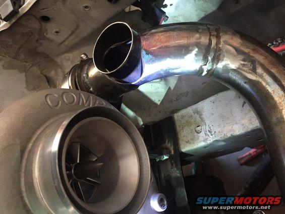 Turbocharger with 'COMP' visible, connected to custom exhaust piping