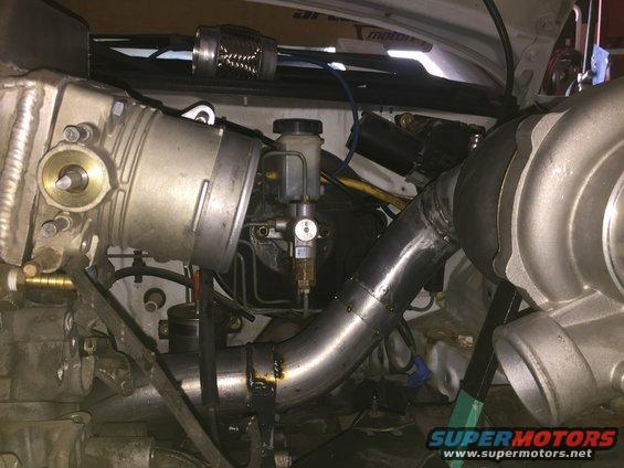 Engine bay with turbocharger, intercooler piping, and brake fluid reservoir