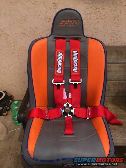 Gray and orange racing seat with red PRP and RaceQuip harness straps