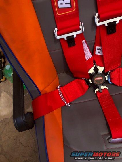 Racing seat with red 5-point harness and orange side panel
