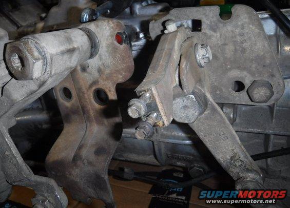 Side-by-side view of the E4OD t-case shifter linkage plate (left) and M5OD plate (bolted on at right).  The portion with the right bolt on the M5OD plate needs to get added into the E4OD plate.
