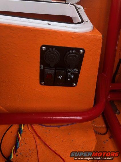 Orange panel with two 12V outlets, a red switch, and a fan switch