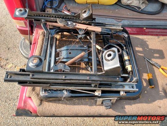 Seat rails and mechanism removed from a vehicle, with tools nearby