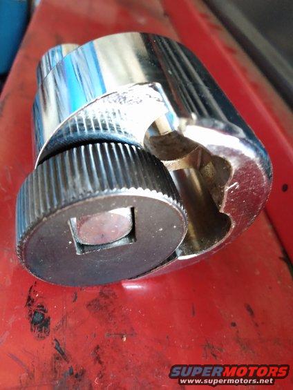 Close-up of a chrome socket wrench part with a knurled black adjustment knob