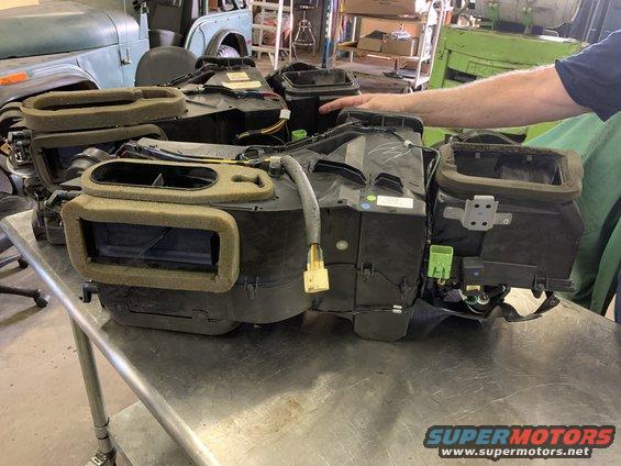 HVAC blower motor housing and ductwork assembly with foam insulation, on a metal table
