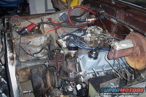 Engine bay with carburetor, distributor, and brake booster visible