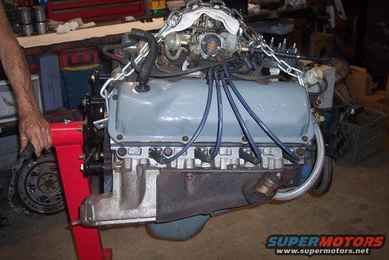 Engine on red stand, grey valve covers with Ford logo