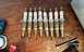 2005 Ford Mustang - A set of ten Motorcraft Platinum spark plugs are shown on a wooden workbench, suggesting a tune-up or replacement.