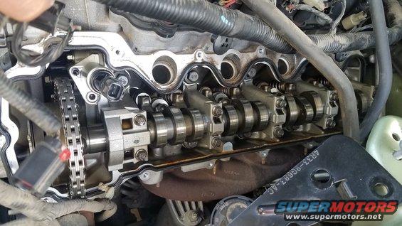 Engine with valve cover removed, showing camshafts and timing chain