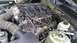 2005 Ford Mustang - The engine bay of a car is shown, with focus on the intake manifold and associated components. Some spark plug wires appear to be disconnec…