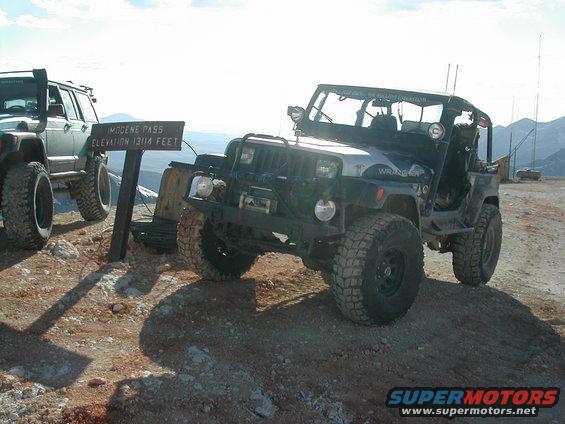 Modified Jeep Wrangler parked next to a sign at Imogene Pass, elevation 13,114 feet. Another Jeep is visible to the left