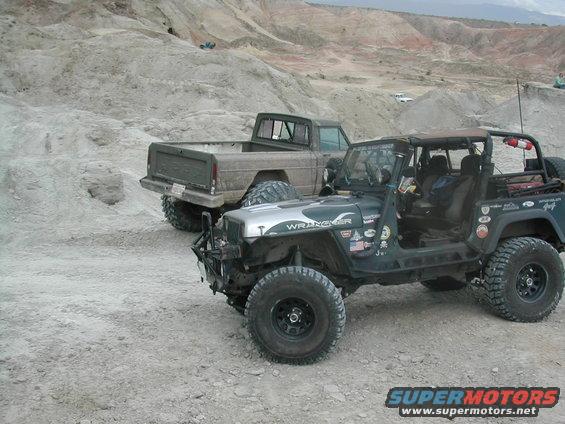 1992 Jeep Wrangler and pickup truck off-roading in a desert landscape