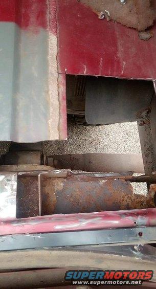 Rusted metal frame and body panels of a vehicle undergoing repair