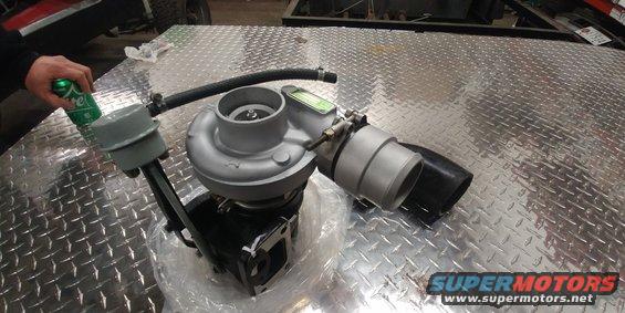 Turbocharger with a green can of soda next to it on a diamond plate surface