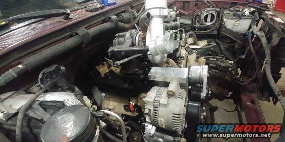 Engine bay with turbocharger and alternator, maroon exterior, under construction