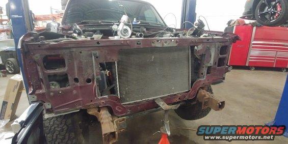 Maroon SUV front end disassembled, radiator exposed, turbocharger visible