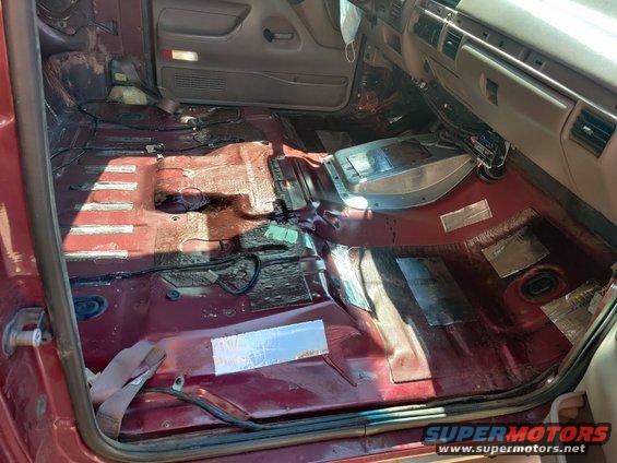 1996 Ford Bronco interior with carpet removed, showing sound deadening material on the floor