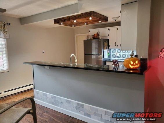 Kitchen island with granite countertop, sink, and a Halloween pumpkin