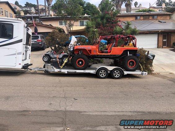 Orange Jeep CJ-7 on trailer, with a toy Jeep and RV