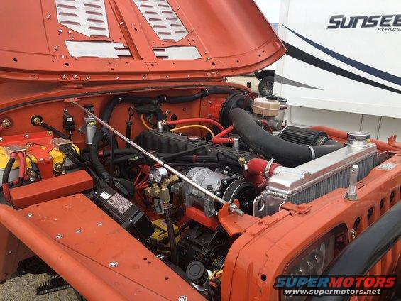 1992 Jeep Wrangler engine bay with orange paint and aftermarket parts