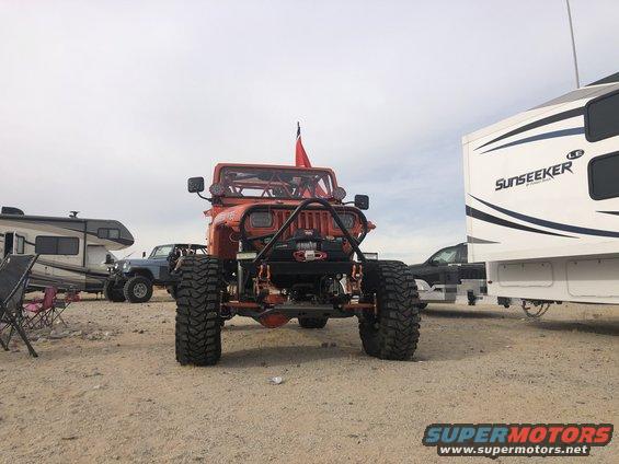 Orange 1992 Jeep Wrangler with large tires and winch, front view