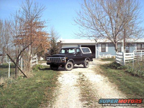 Black 1978 Ford Bronco parked on a gravel driveway