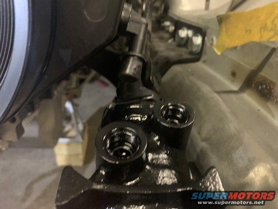 Black power steering pump with two ports, part of a vehicle's steering system